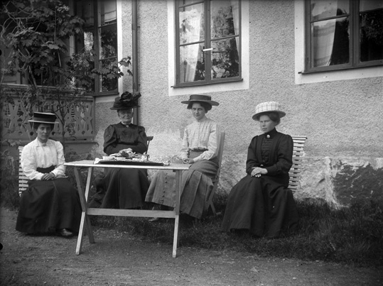 Fyra damer sittande i trädgård, Lillhärad ca 1910.