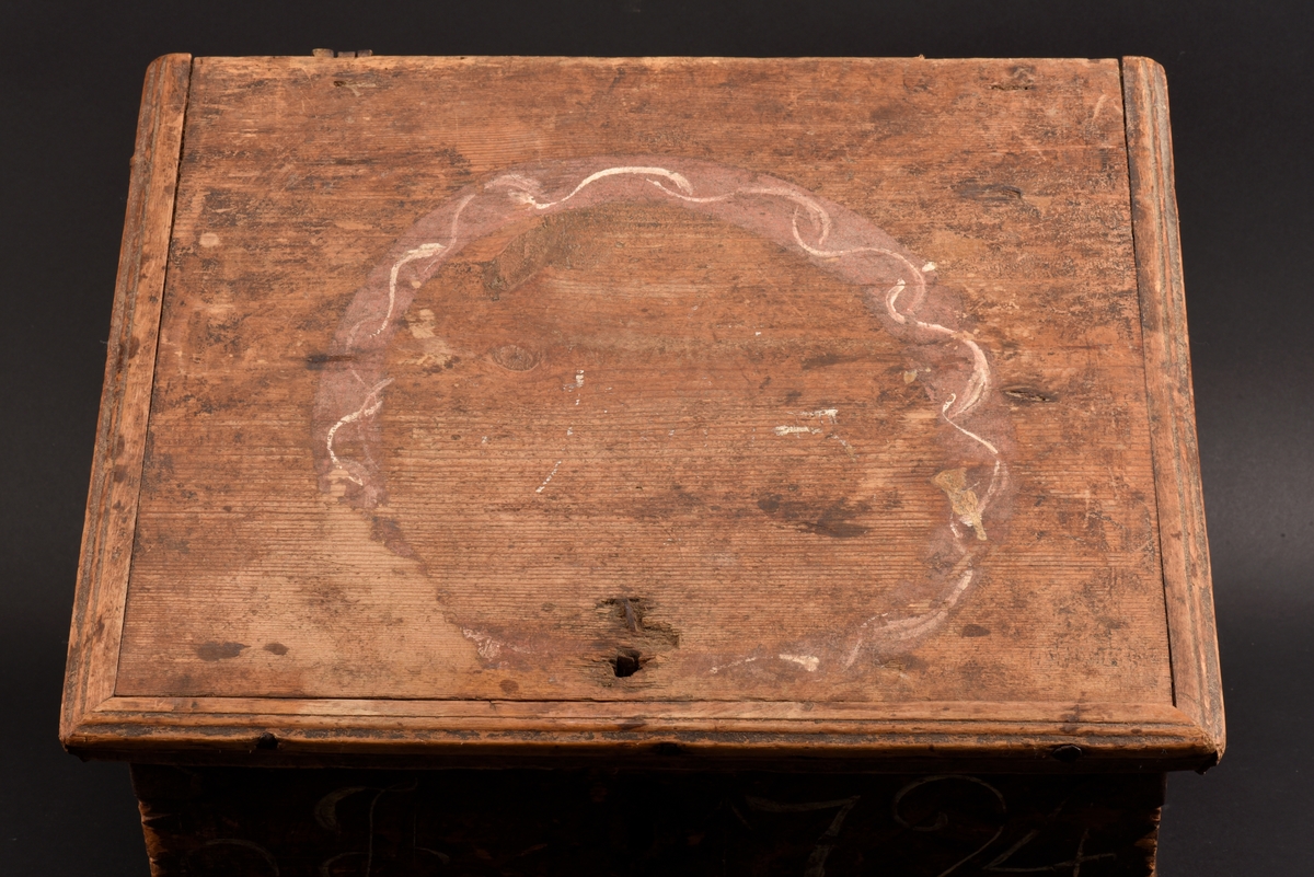 Rektangulärt skrin med plant lock tillverkat av furu. Målat i brunt, med dekor på lockets ovansida, en målad krans i rött och vitt. På framsidan ditmålat årtal "1794" i vitt. Beslag, spikar och gångjärn i järn. Nyckel saknas och ett gångjärn sitter löst.