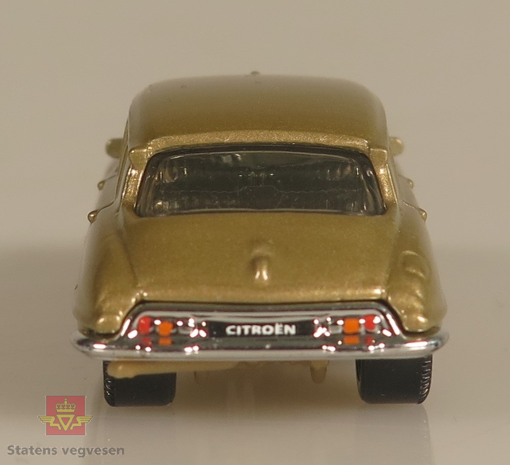 Primært beige modellbil laget av metall. Skala: 1:65