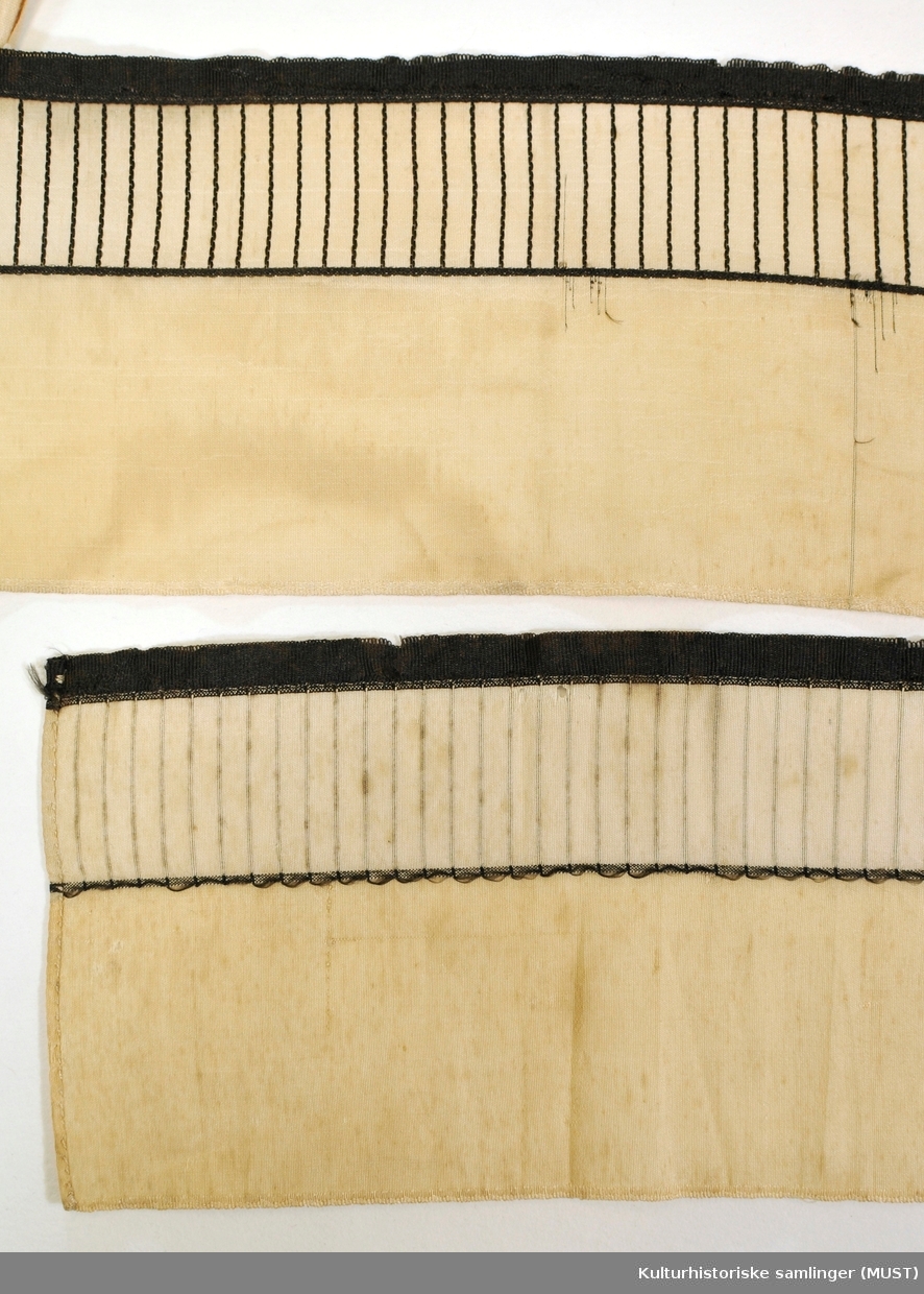 Firkanta pull med avrunda hjørner.
Sydd av mønstervevde silkebånd.
Sløyfebåand av samme slag er sydd fast (sekunder) langs nedrekant knytebånd, og smalt heklebånd med striper.
Det er festet i hver side av løpegang, og er udelt på utsiden med en rameløkke



Hovedstoff sammensatt av mønstret silkebånd av samme type som knyttebåndene som er 8 cm. brede. To sett knyttebånd. Det andre båndet 2 cm. bredt er av tynn fast bomullslerret. Hele luen er fòra med tynn, fast bomullslerret. Luedelene er sammensydd med spilesøm.