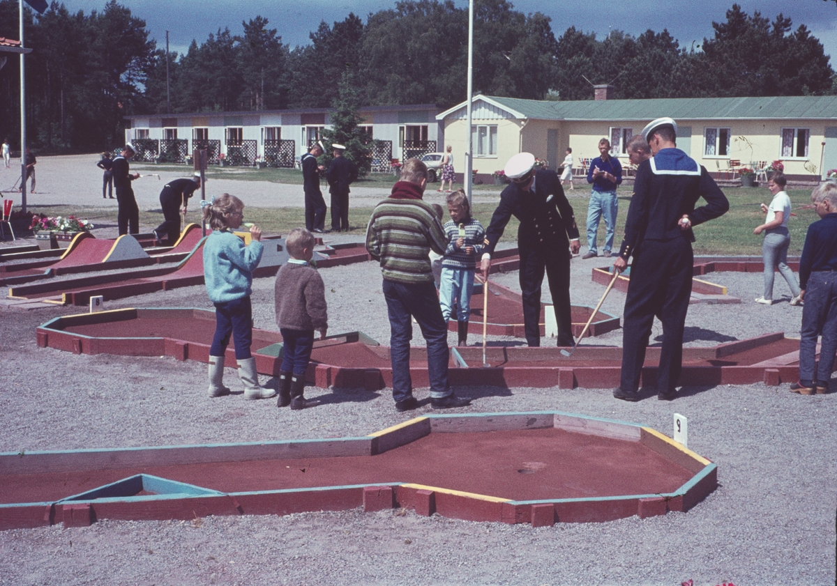 Bilden visar marinkårssoldater och barn som spelar minigolf.