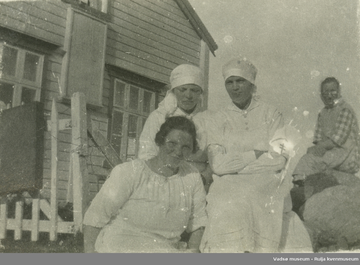 Kvinner i sykepleieuniformer poserer i solen foran Kistrand pleiehjem i Porsanger, Finnmark. 1920-1925.