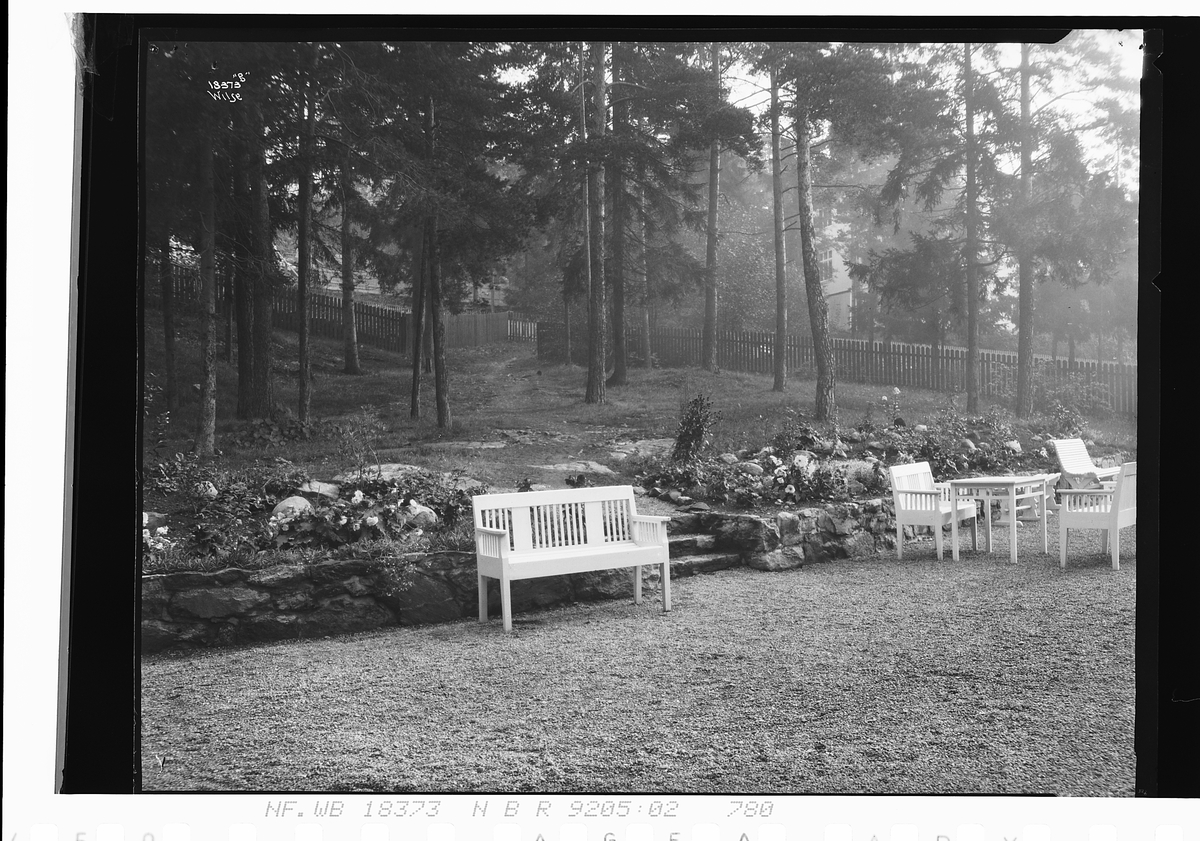 Del av hage med benker på Nordstand husmorskole. Fotografert 1924.