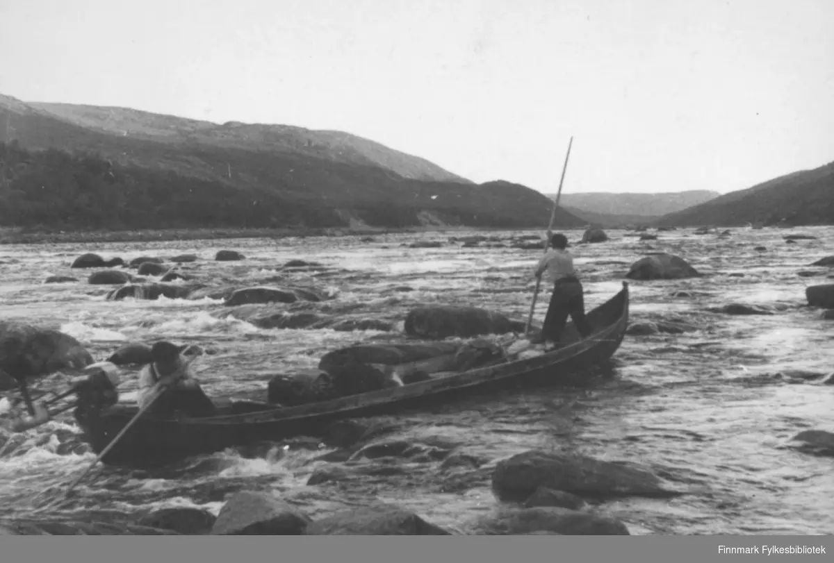 En elvebåt med to menn ved Tanaelva på 1950-1960 -tallet.