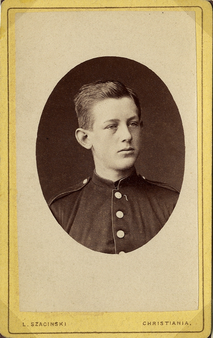 Foto av en ung man i militäruniform.
Bröstbild, halvprofil. Ateljéfoto.