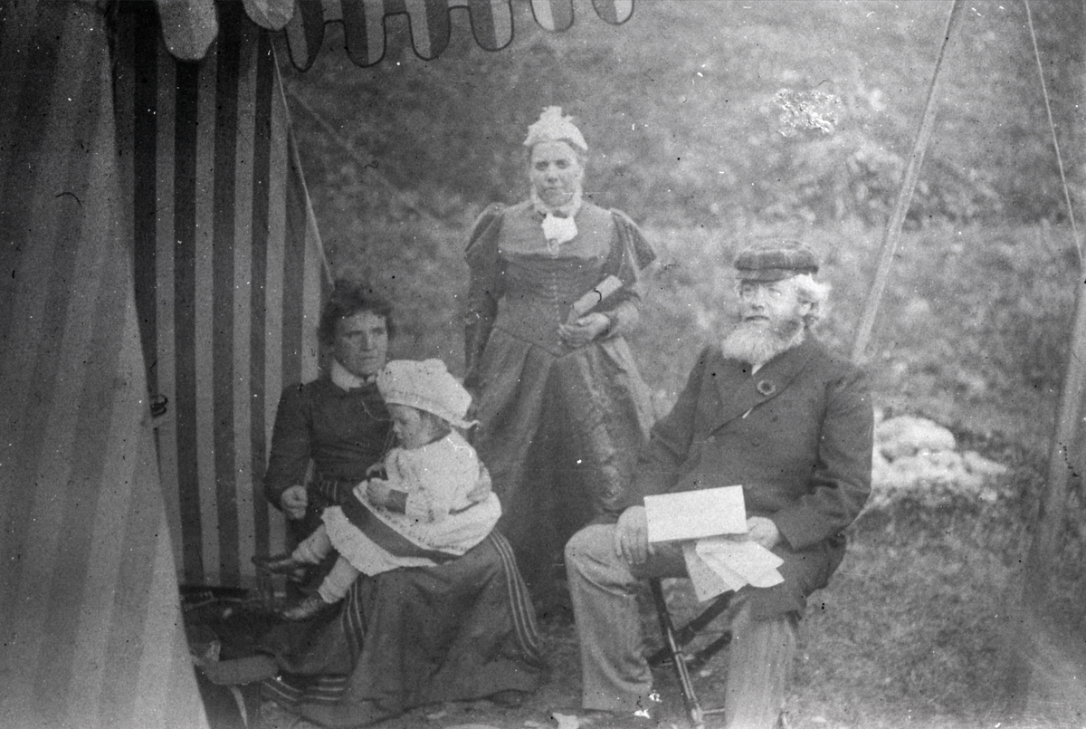 Gruppeportrett av familien Aston ved et telt.