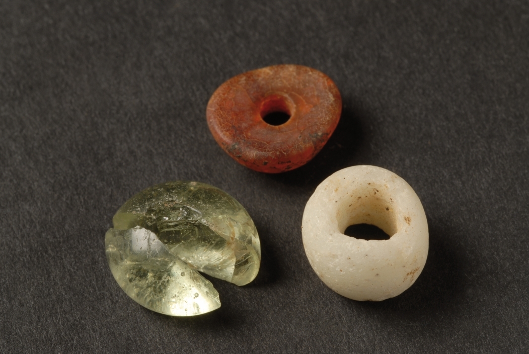 En möjlig spelbricka i olivgrönt glas, en vit glaspärla samt en bärnstenspärla påträffad i en skelettgrav, A 31209, på gravfältet RAÄ Barnarp 29:1, L1974:2724 på Torsvik i Jönköping. I graven påträffades rester efter en individ, troligen pojke, på 12-15 år.  Se även bild JMF.00328:13 och JMF.00328-14. Datering 640-685 e.Kr.