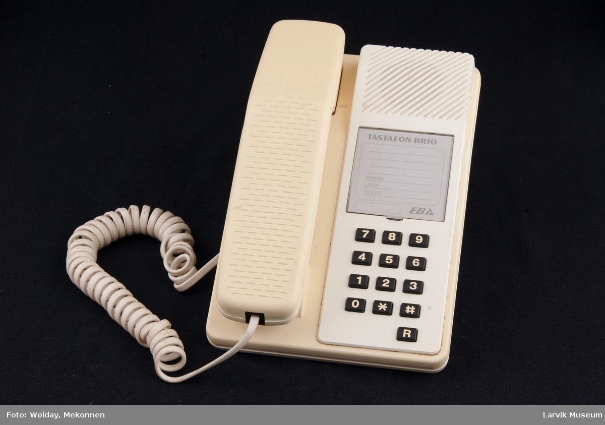 Tastafon BRIO. Tastatur på høyre side bord. Telefon i holder venstre side.