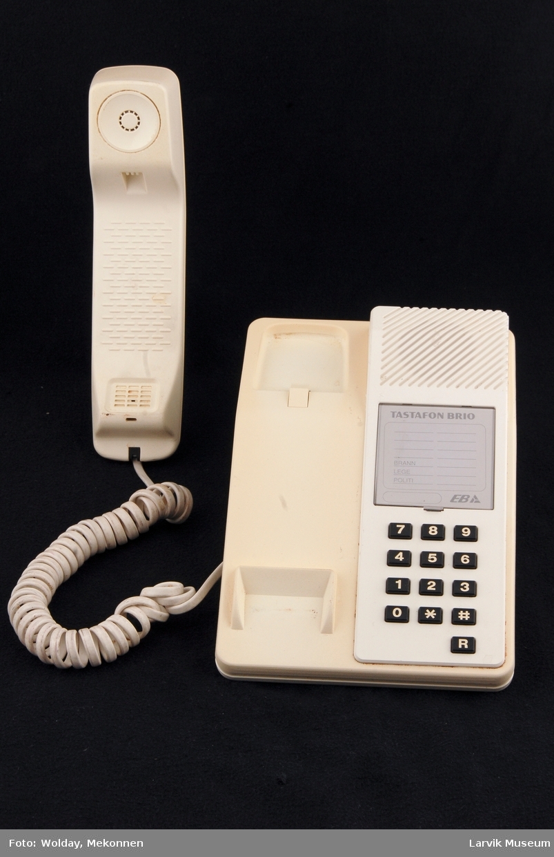 Tastafon BRIO. Tastatur på høyre side bord. Telefon i holder venstre side.
