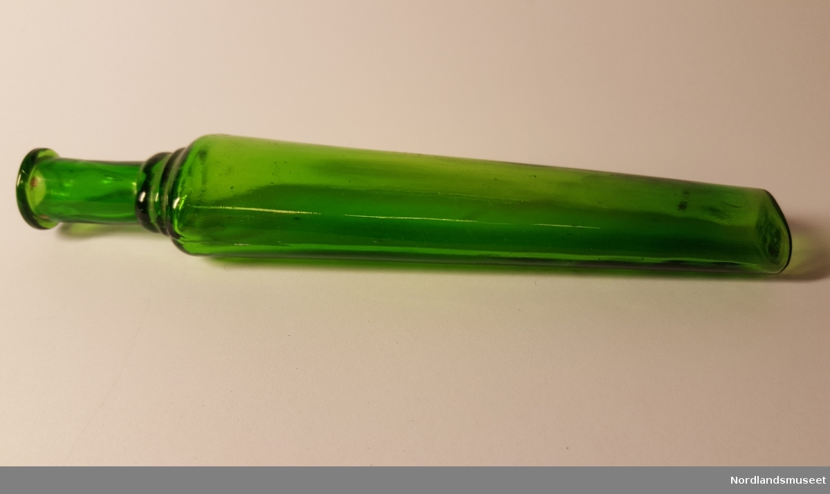 Grønn glassflske med smal, lett skrånende korpus. lang hals m/munningsrand. Riller i glasset mellom hals og korpus. to synlige små bobler i glasset