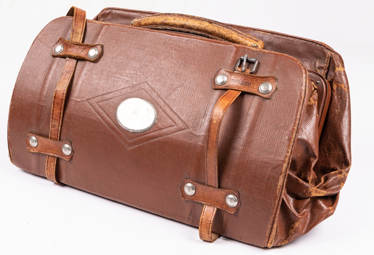 Läderväska, brun. 45x22 cm. 2 st. Läderremmar att hålla samman väskan med. På ena sidan påsatt plåt med plats för monogram.