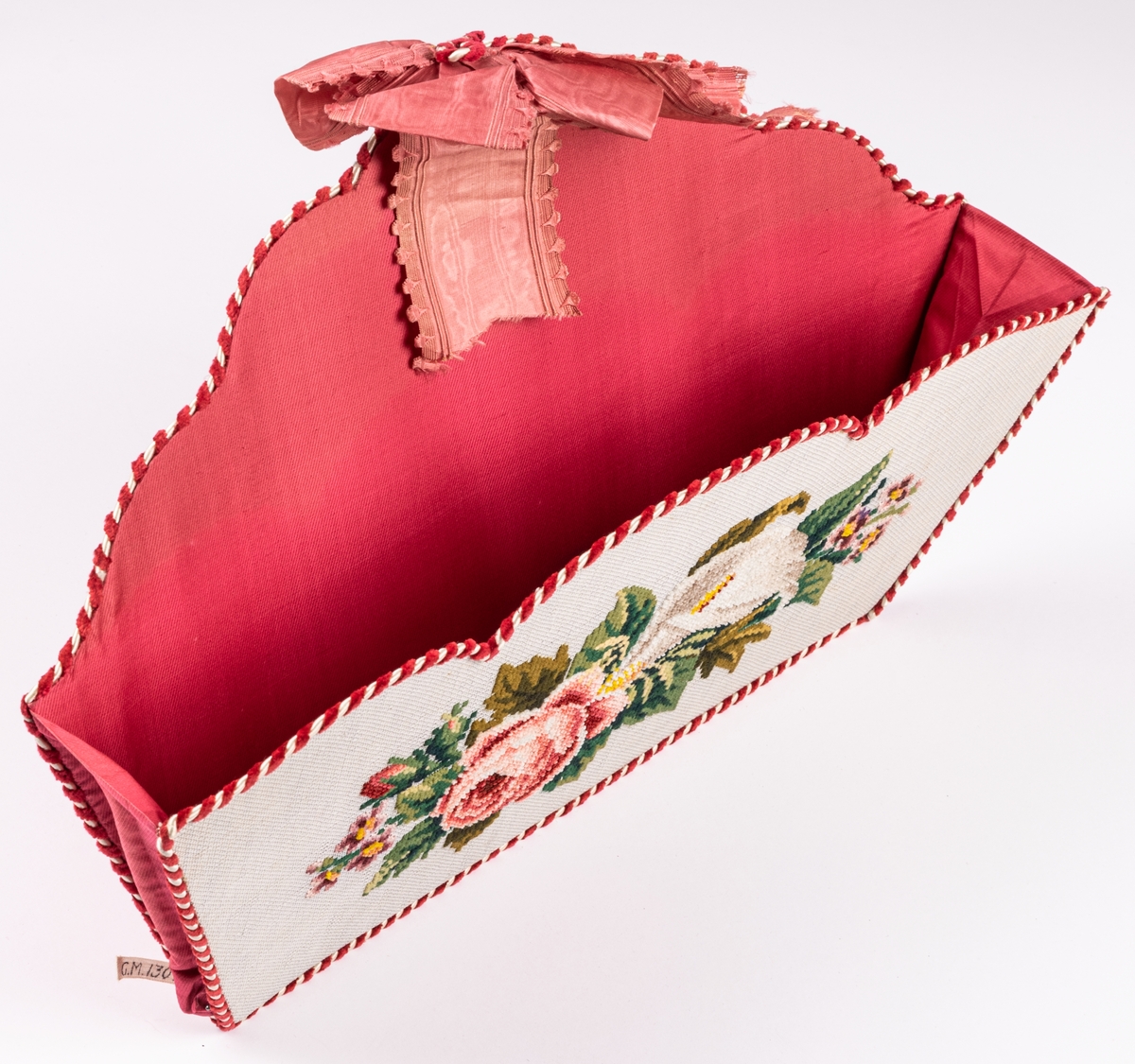 Handskkorg att hänga på väggen, broderad på stramalj, fodrad med rosa siden och kantad med röd och vit snodd.