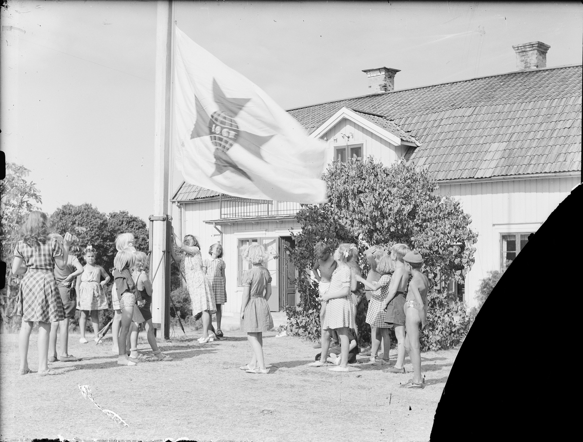 Barnkoloni - barn och kvinna vid flaggstång med I.O.G.T. flagga, Sandika, Harg socken, Uppland