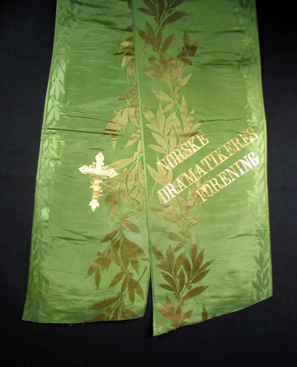 Begravelsessløyfe i grønn mønstret silke med tekst i gull.