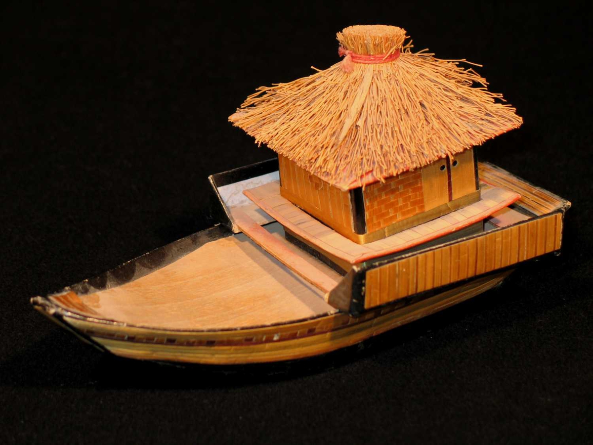Flatbunnet husbåt laget i papir og strå. 