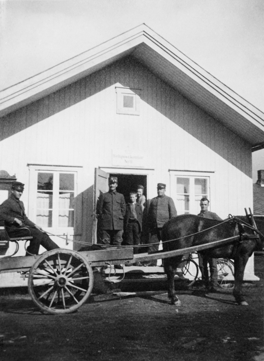 postkontor, eksteriør, feltpost, feltpostkontor nr. 11 på Værnesmoen 1911, kusk med hest og vogn, hus, fem personer foran døra, sykkel, skilt