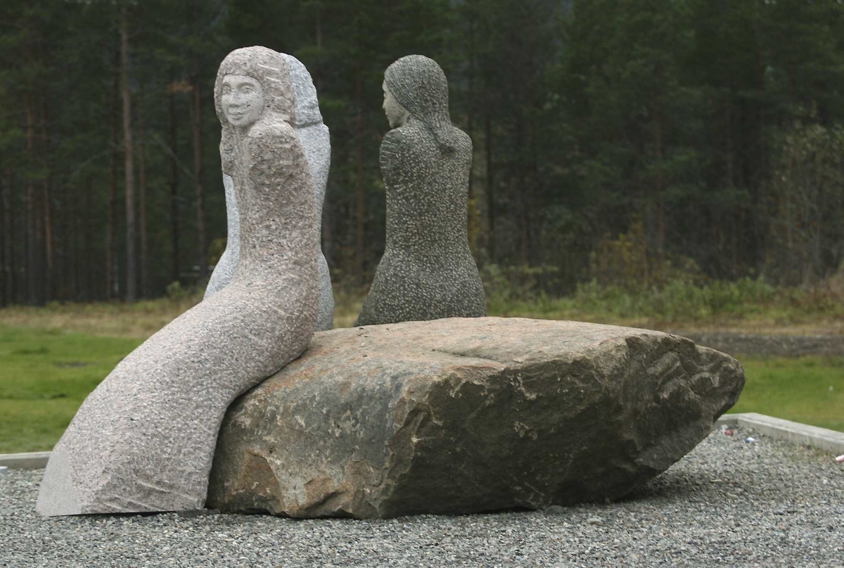 Skulpturgruppe i granitt, viser tre sittende kvinner i samtale på en sirkelformet stein meddiameter på a. 3 meter. steinen kvinnene sitter på er en naturstein hentet fra Lødingen.