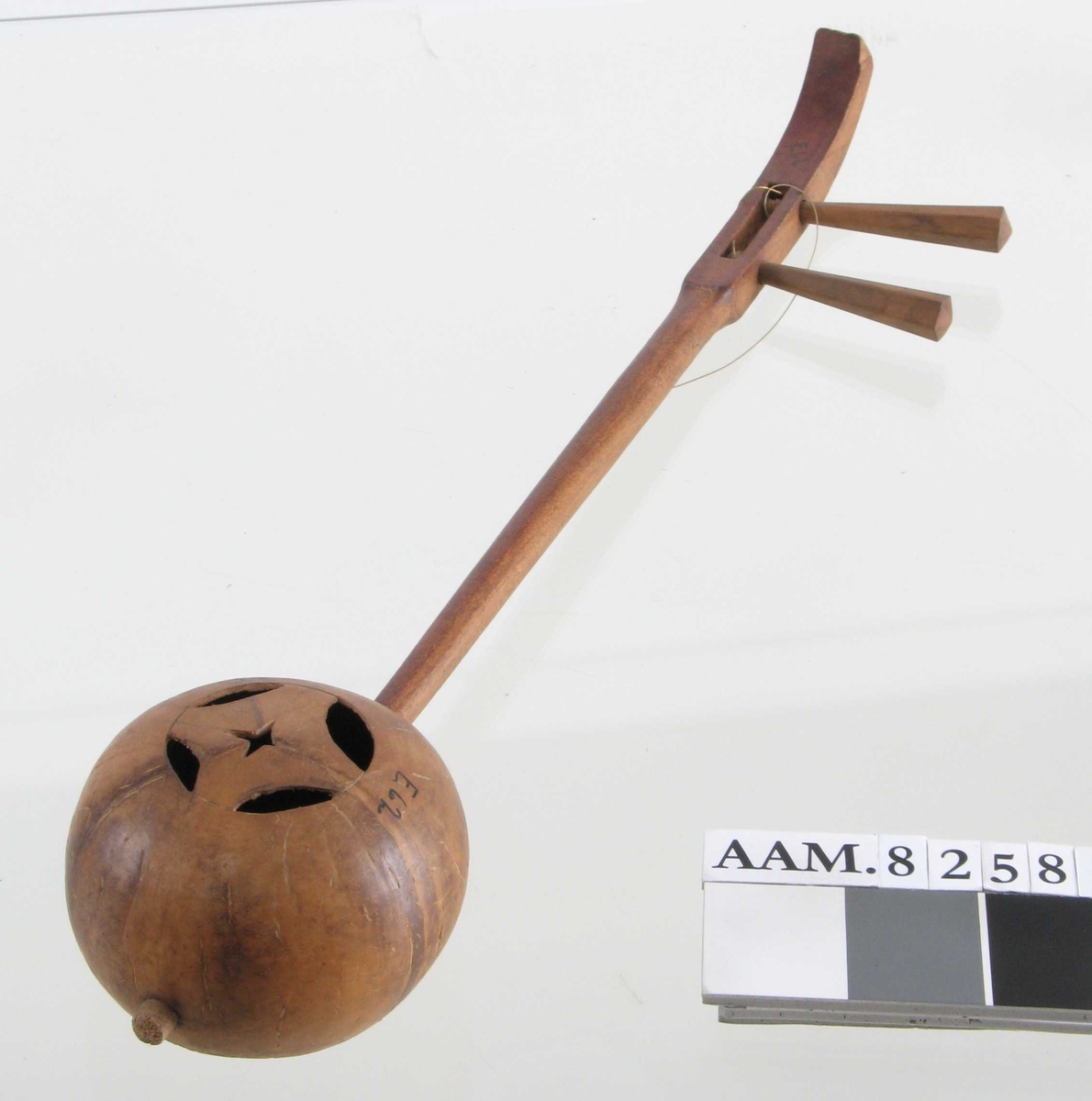 Musikkinstrument,  Kina.  Tre,   kokosnøttskall.  Instrumentet laget av en tom kokosnøtt, med skaft av tre.  Trolig et  strengeinstrument, men strengene borte. 