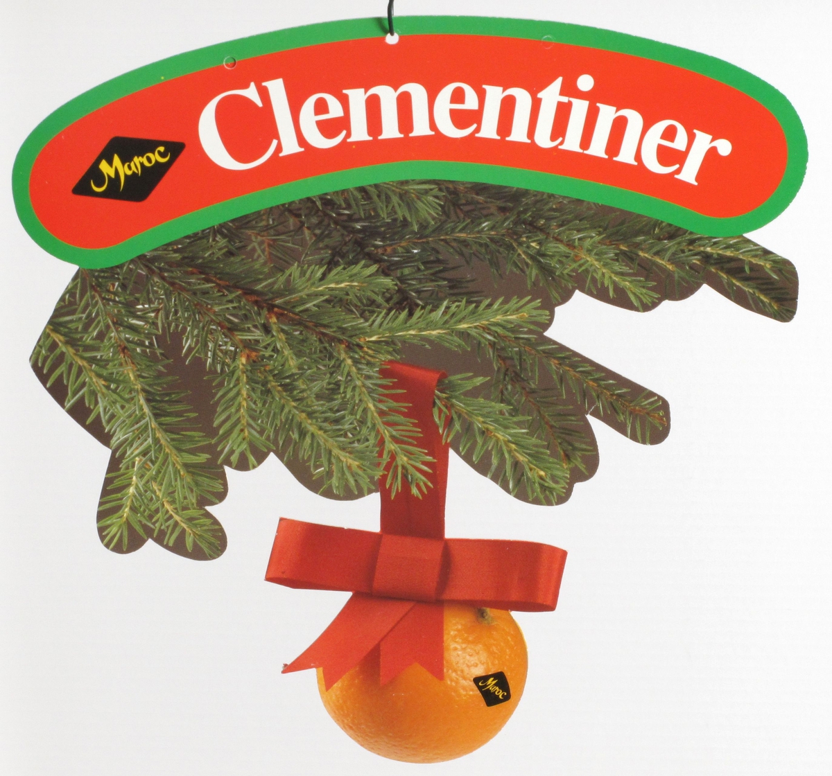 Clementin hengende i rødt juleband under grankvist.