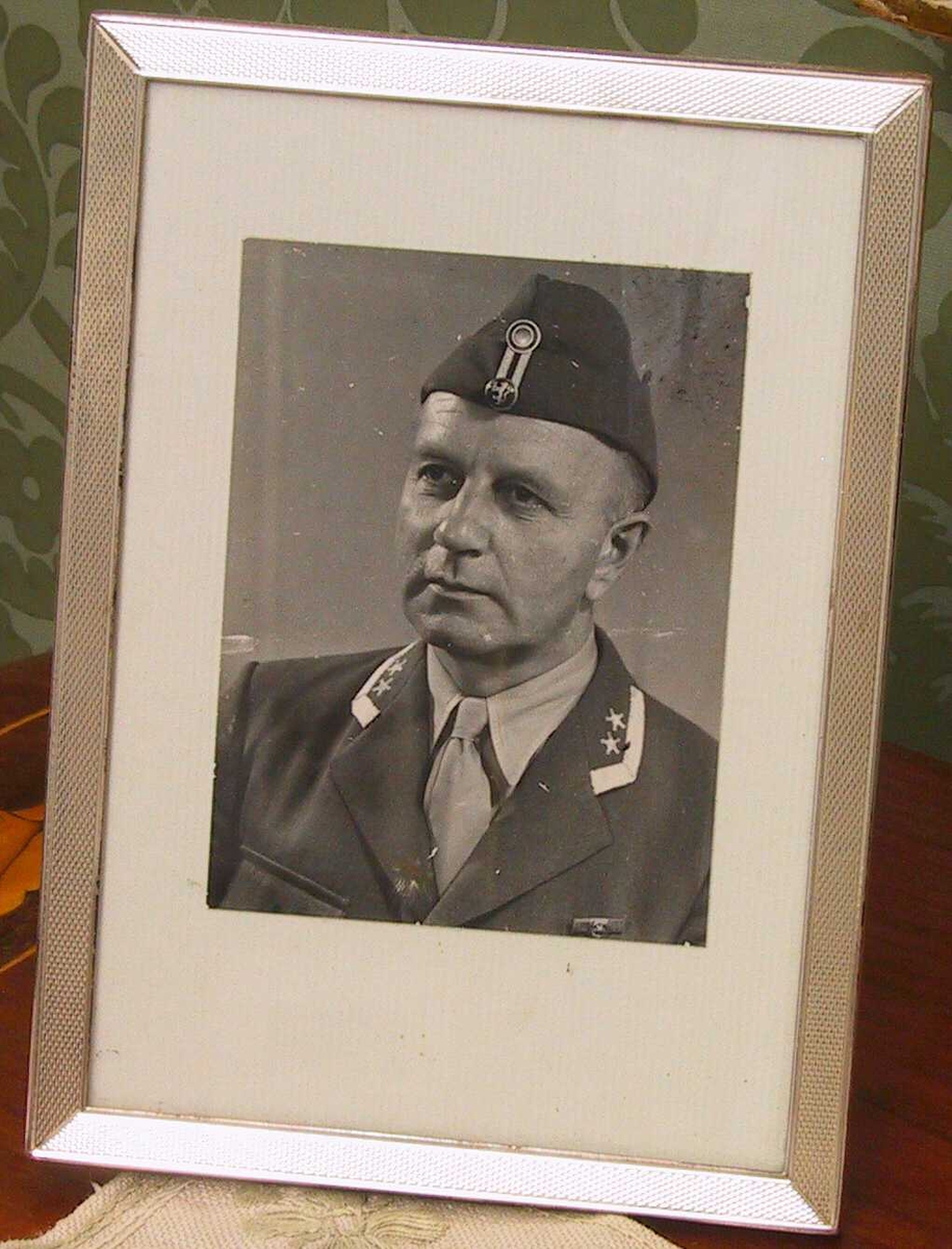 Portrett av  Harald Juell i oberstuniform, ca. 1947.  Brystbilde, halvt venstrevendt,  hodet litt bøyd mot høyre  Alliert uniform med lue. Anta. tatt i Tyskland. hvor Juell var oberst i  de allierte okkuasjonsstyrker etter krigen. 