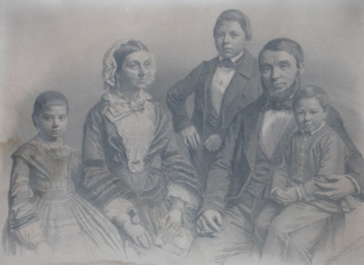 Gruppeportrett, familie, mor og far med tre barn. Far sitter til høyre med minstegutten på fanget, lengst til venstre står datteren ved siden av sin mor som sitter, og mellom mor og far står den eldste sønnen. 