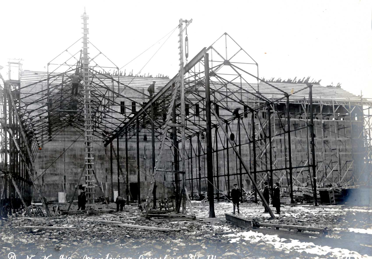 "03/01-1914" Nitriden. Reising av jernkonstruksjoner for Ovnshus I. Omformerstasjonen i bakgrunnen.