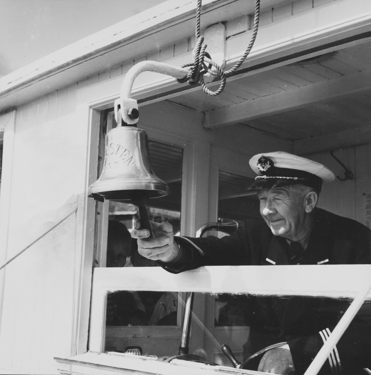 Kapteinen ringer i skipsklokken ombord i D/S Turisten