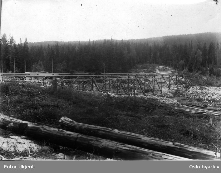 Byggingen av den nye Øyungsdammen (ferdig 1916). Reisverk i tre. Tømmerstokker.