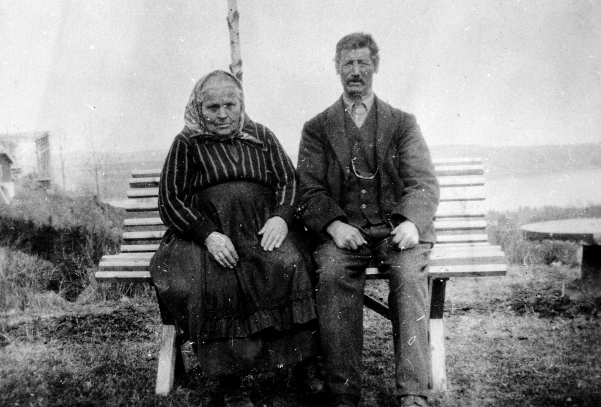 Berthe Hauglien (1851-1938) og Lars Hauglien f.1854 på en benk i Hauglien, Stavsjø, Hedmark.