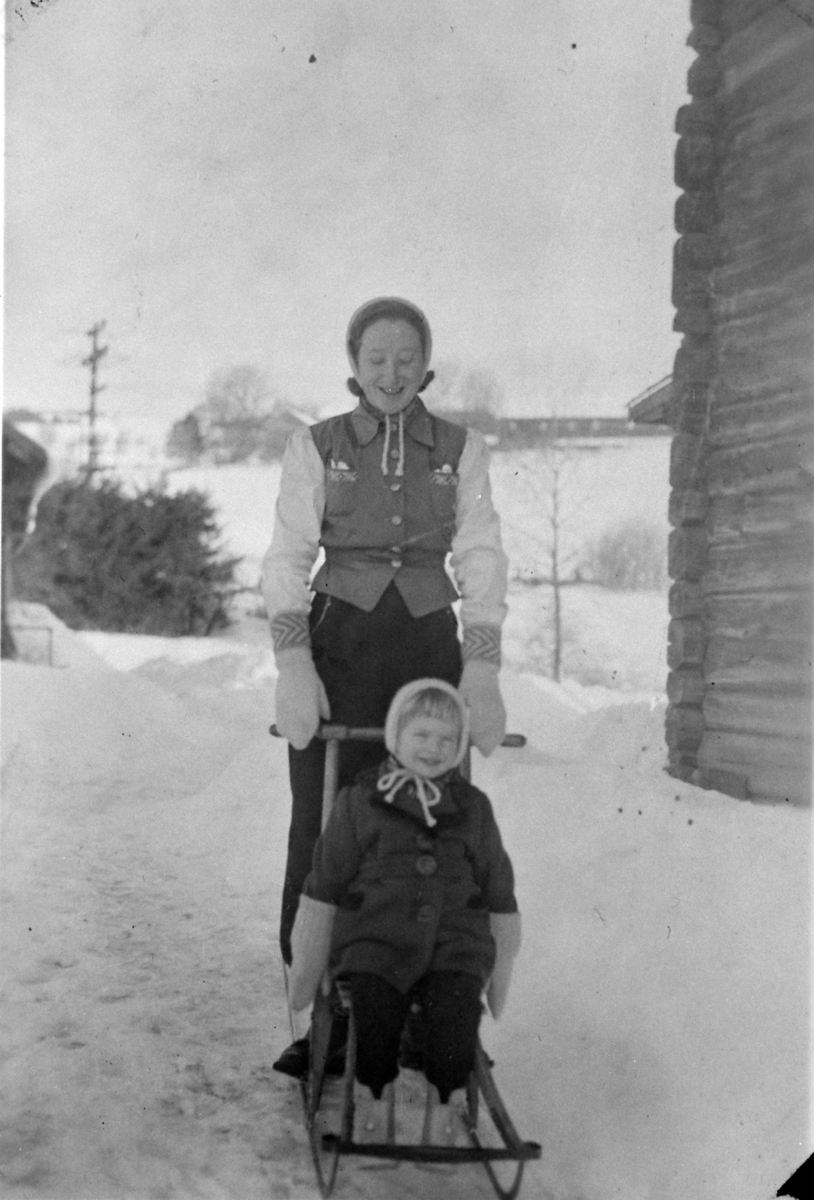 Ester og Inger utenfor Dalheim, ved Præstvægen i Veldre, Ringsaker. Tokstad gård i bakgrunn.