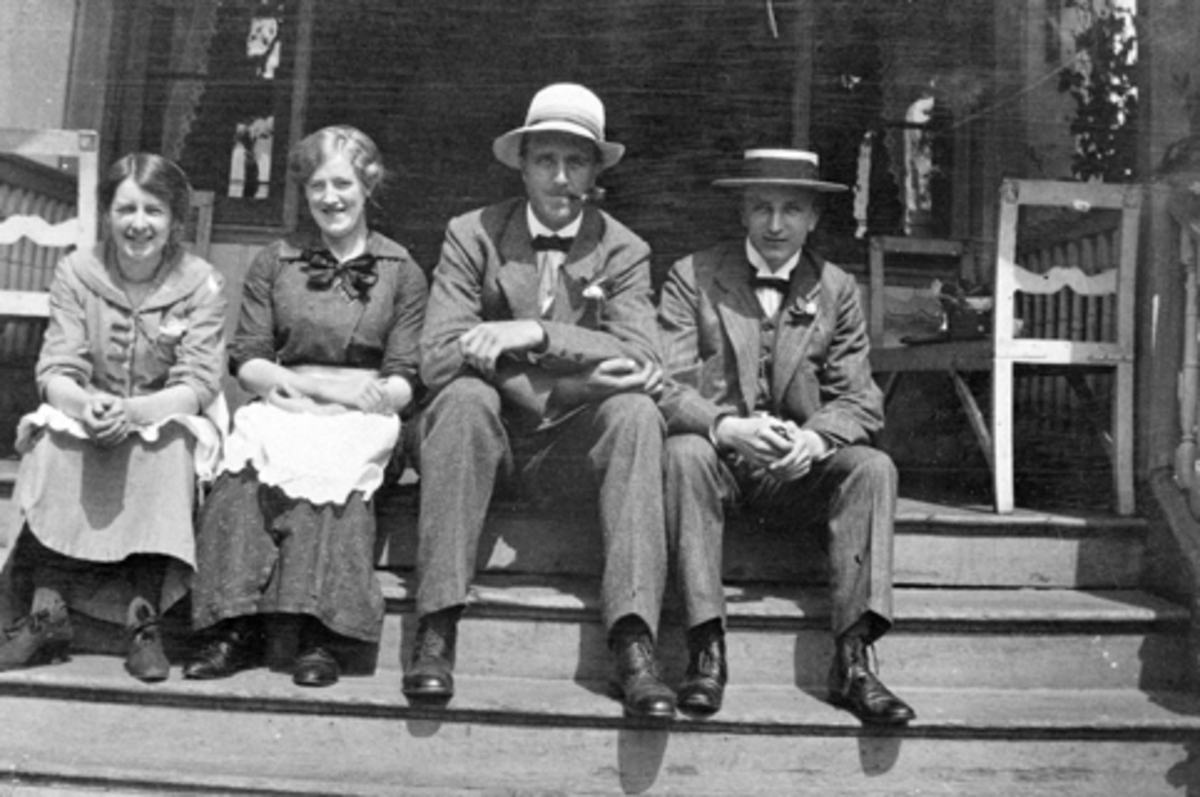 To menn og to kvinner sitter på trappa på Smsal gård, Ringsaker.