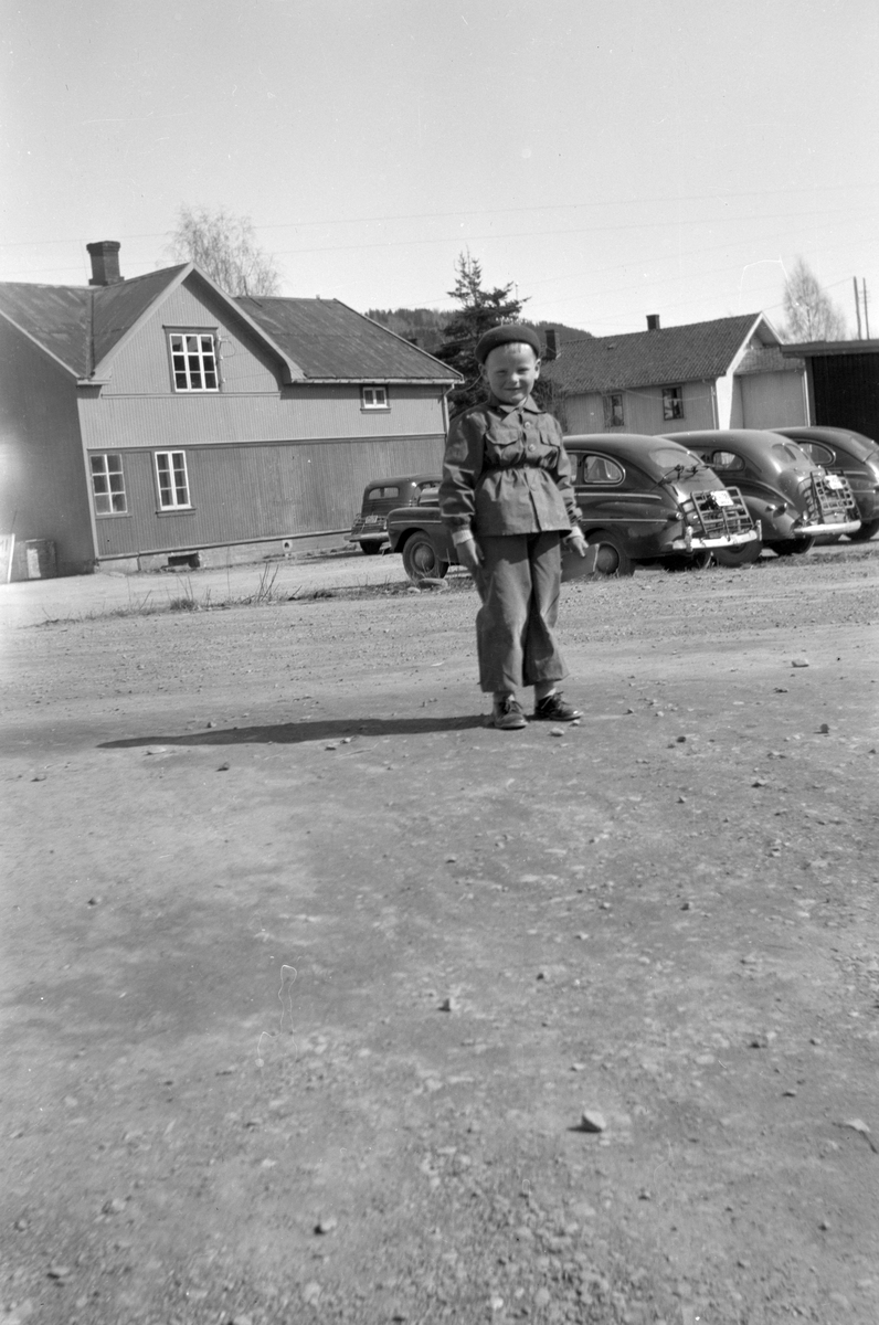 Brumunddal, gutt, drosjer. Brede Mordal f. 1946 med drosjeholdeplassen i bakgrunnen. 