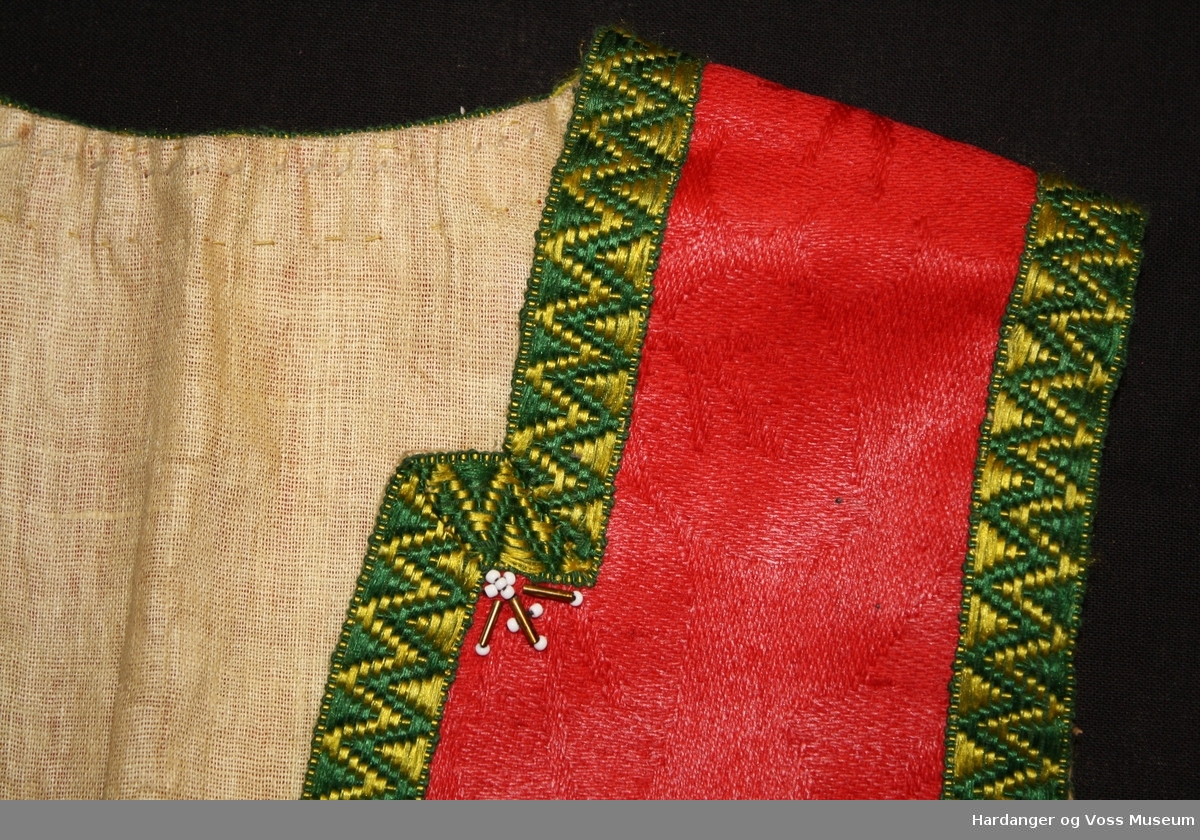 Raud ulldamask, kanta med band i fargane grønt og gult, litt perlepynt framme