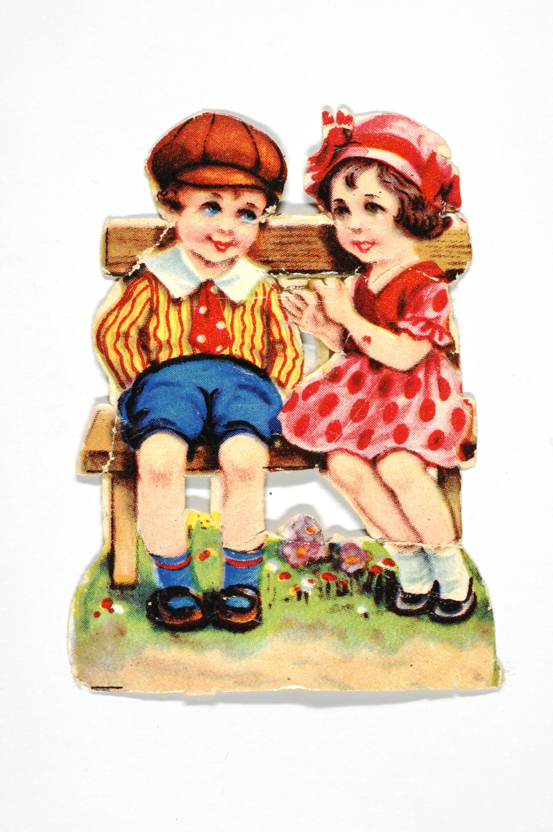En jente og en gutt sitter på en benk. Blomster på marken.