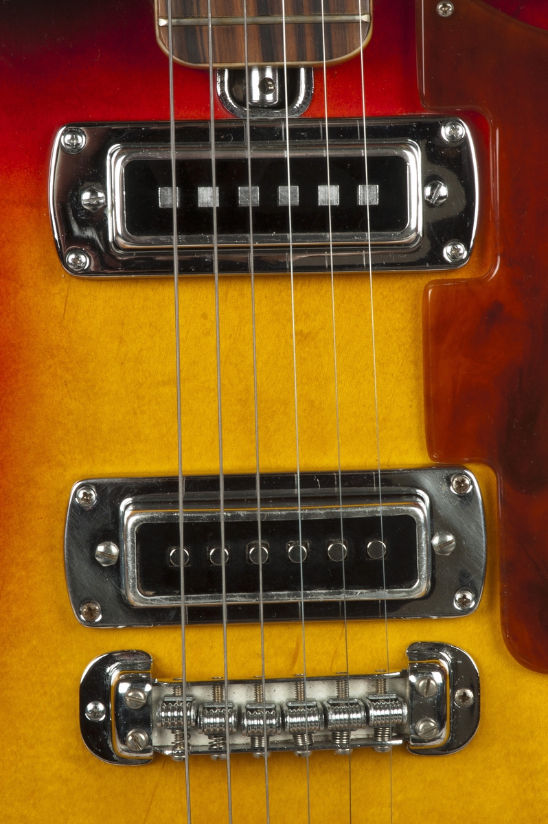 Elektrisk gitar med hul kropp ("hollow body") og dobbel cutaway med finish i sunburst. To Teisco-pickuper med individuelle volumkontroller. Tonekontroll og tonevelger (rhythm, solo, bass).