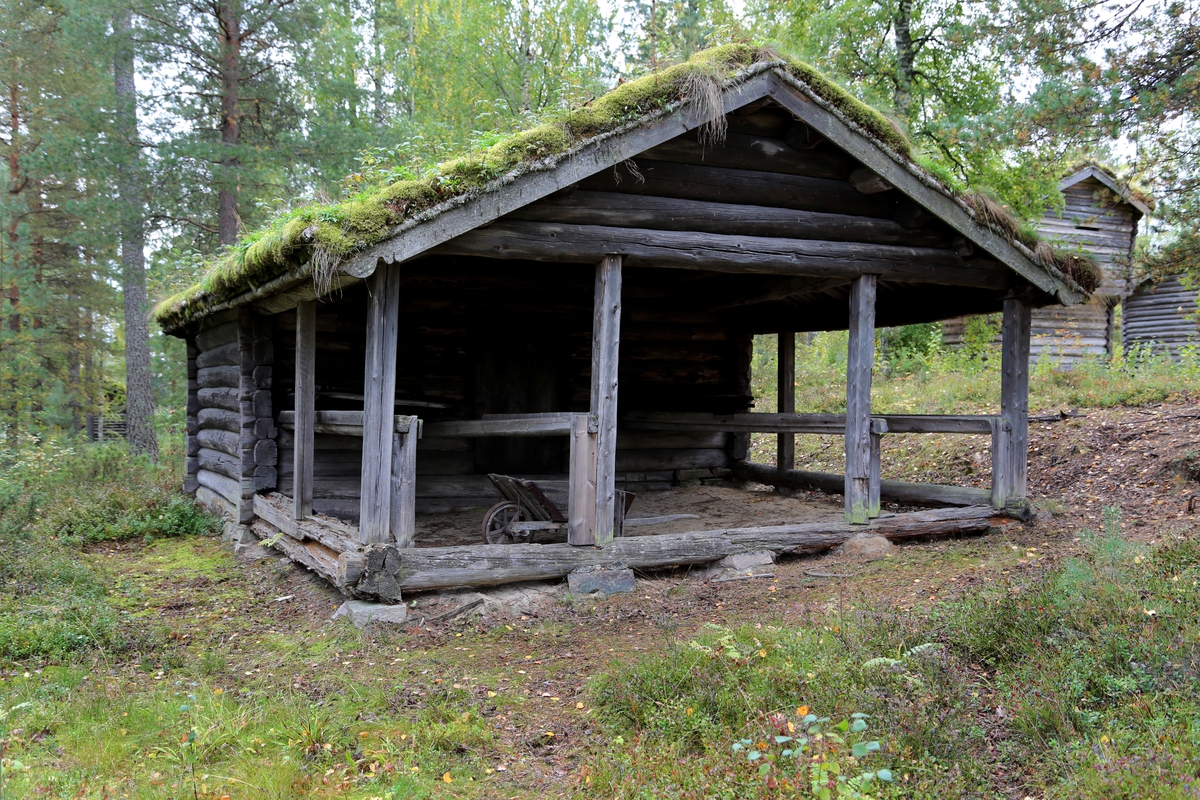 Bastu/tørkehus i tømmer med en stor, åpen "sval" foran inngangen, der det er renner eller bånd for inn- og utføring av det som skal tørkes. Huset har en ovn av stein