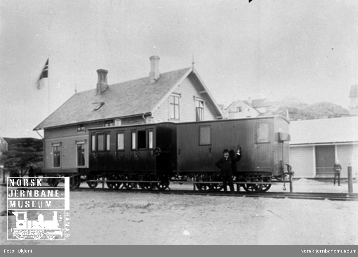 Konduktørvogn, personvogn og godsvogn foran Lillesand stasjonsbygning