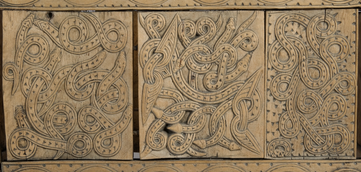 Fire søyler med skåret dyrehode-ornamentikk, sammenføyet med tverrbord og fyllinger. Bunn er åpen foruten to tverrstaver. Hele utsiden er rikt dekorert med utskåret dyr og ranker.