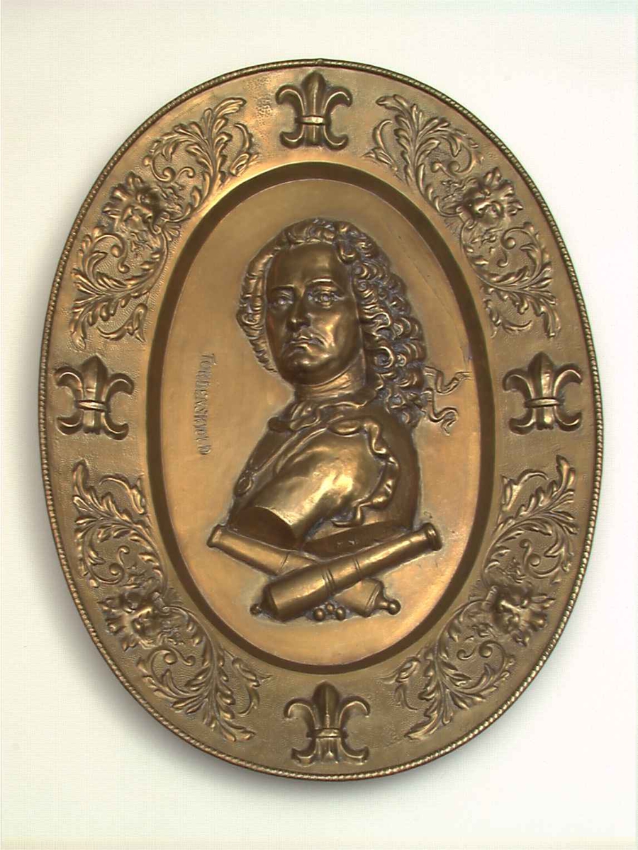 Messing. Ovalt, i bunnen Tordenskjolds brystbilde i relieff, derunder 2 korslagte lavetter, border og franske liljer, akantus og løvemasker.