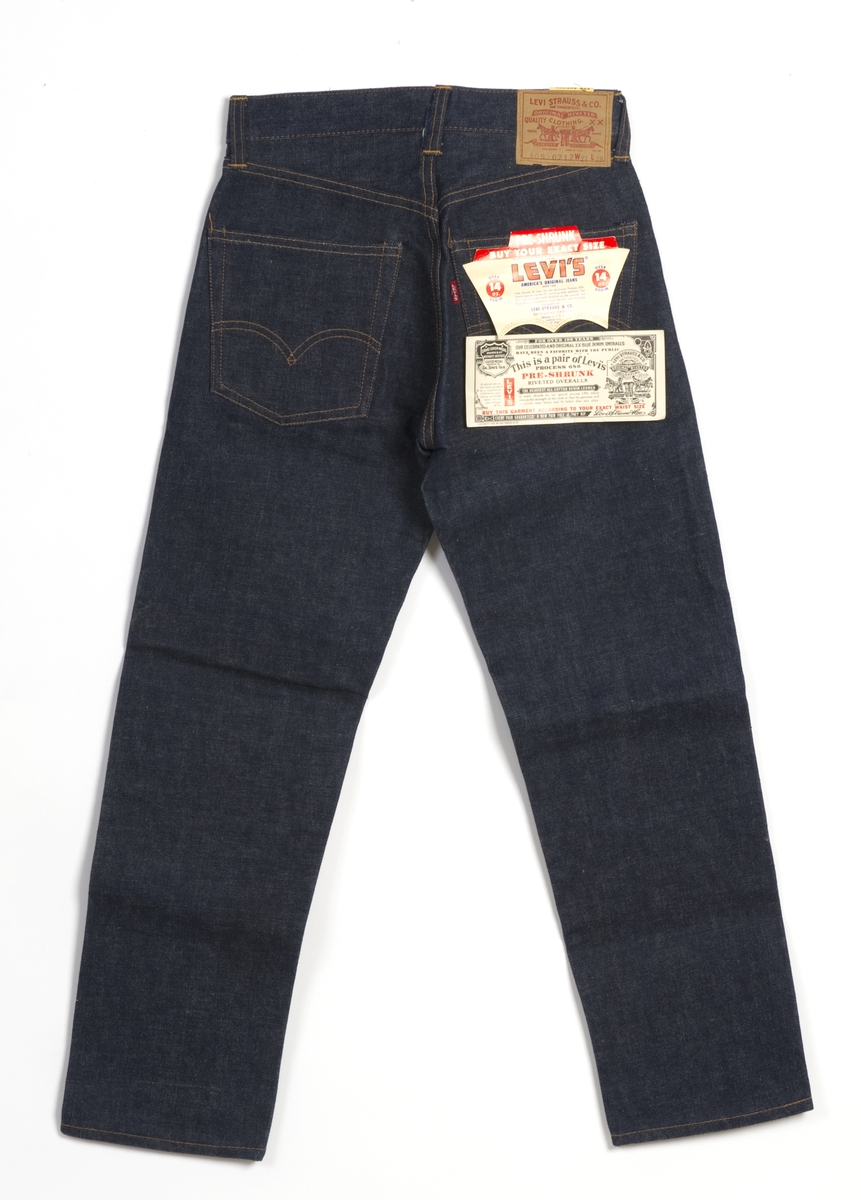 Nye blå jeans bukse, str. W 27 L 28. Lærlapp på høyre bakside med varemerket, modellnummer og størrelse. To originale salgsetiketter på høyre bakside. En prislapp fra Humana, festet på venstre forside.