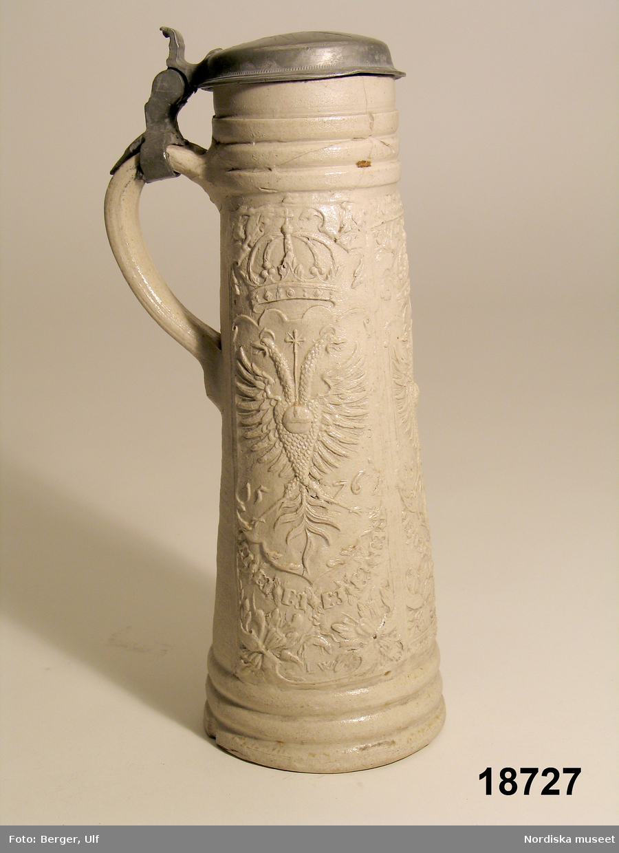 Krus av grått saltglaserat stengods, så kallad "Schnelle", daterat 1576. Lock av tenn. Tillverkat i Siegburg, Tyskland. 
/Tegnér 2005