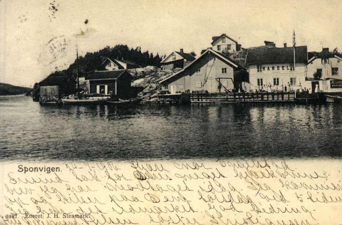 Postkort. Mange damer står på bryggen foran en landhandel, flere båter ligger til kai i Sponvika, Halden. Stemplet 25.07.1906.