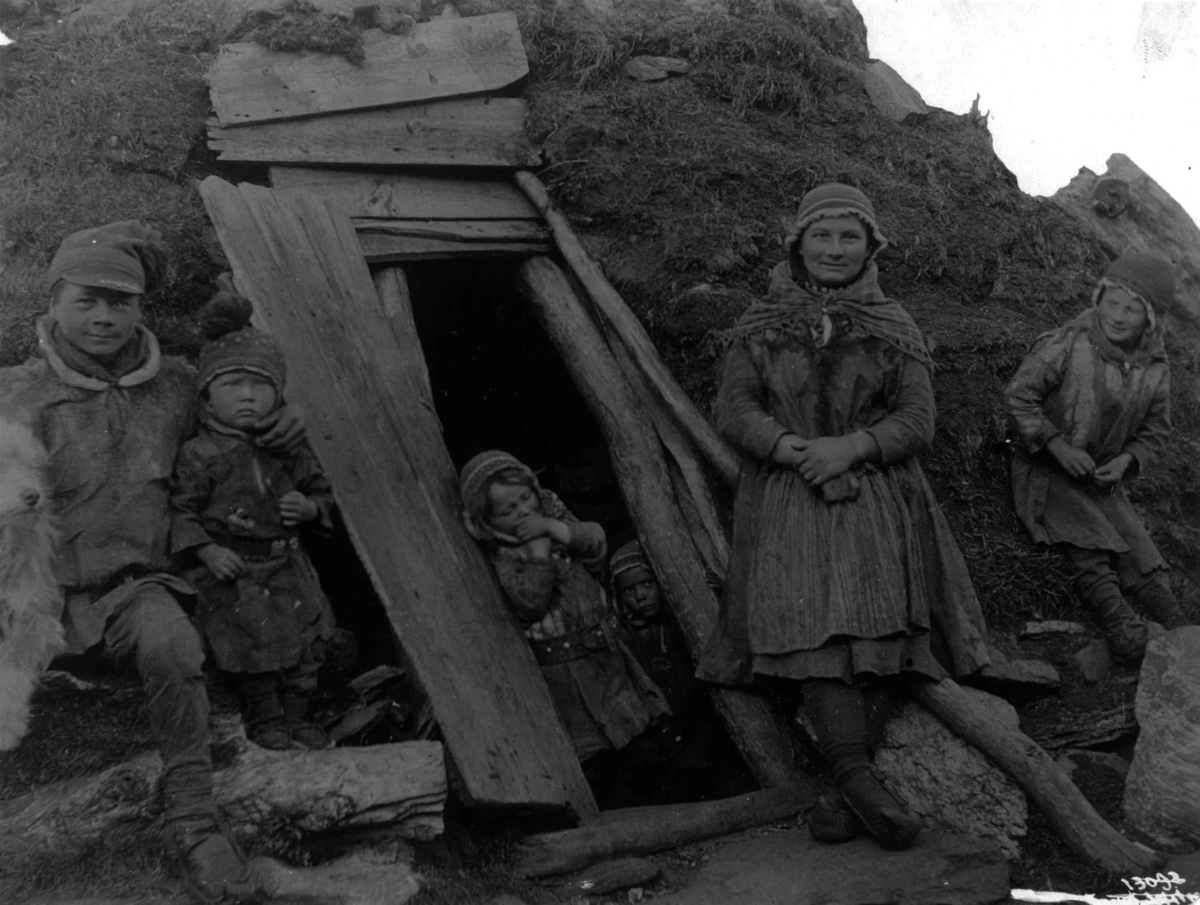 Mann, kvinne og fire barn ved inngangen til en gamme. Sverige? 1911.