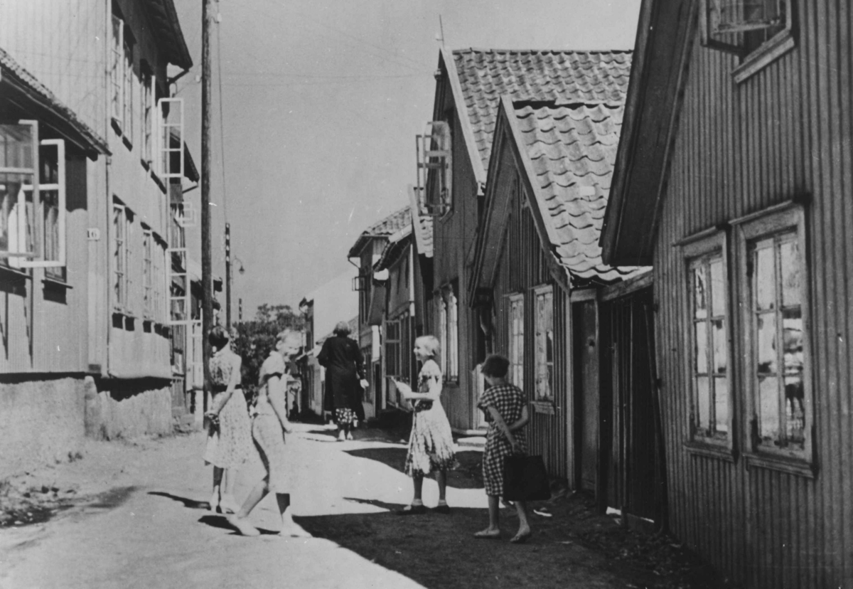 Gatebilde fra den gamle bydelen i Tønsberg. Fire barn leker blant gatens trehus.