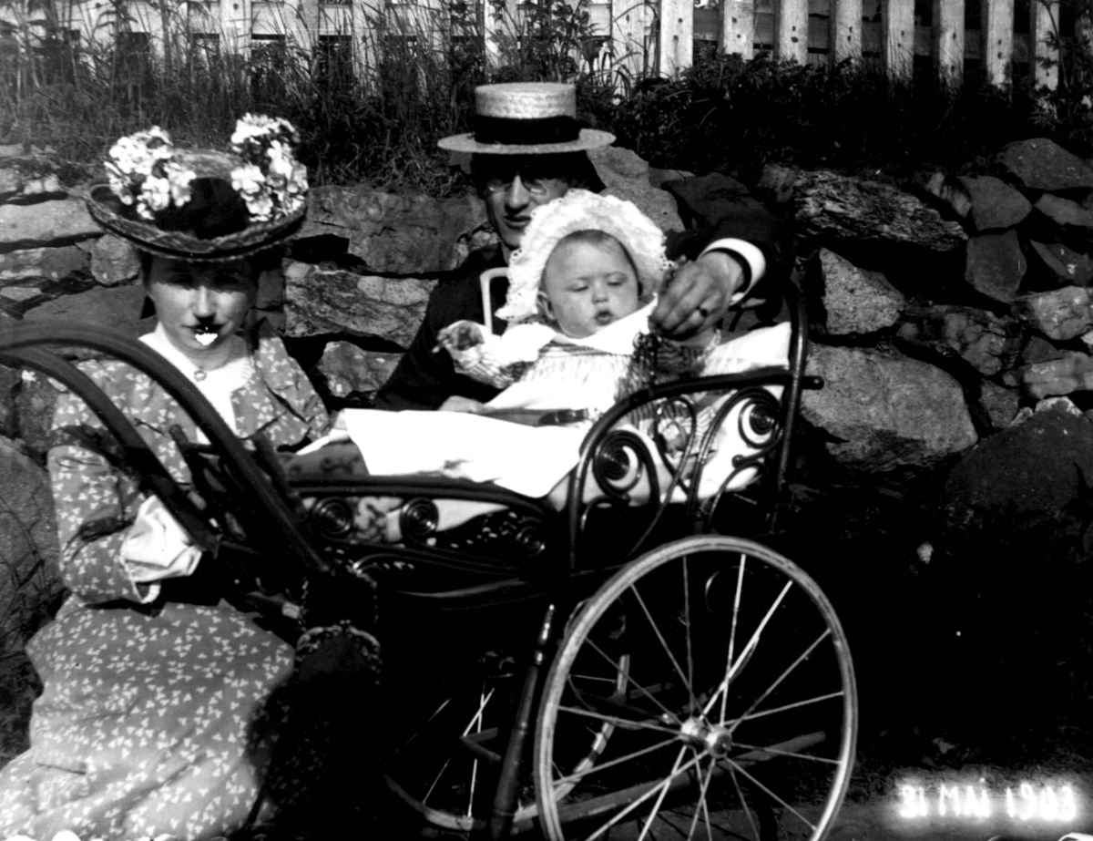 Familiegruppe, ukjent sted, 31.mai 1903. Familien Urbye med sønnen Hans (født 1902) i barnevogn utendørs.
