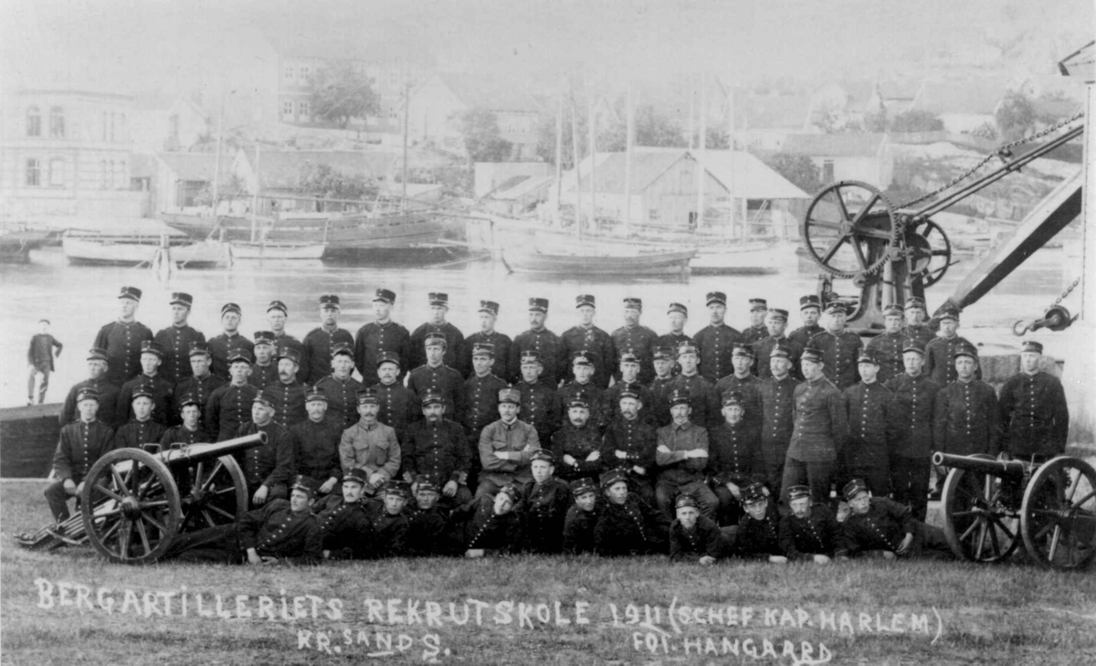 Gruppebilde. Bergartilleriets Rekrutskole, 1911. Kristiansand, Vest-Agder. Sjef kaptein Harlem. Foto Hangaard.