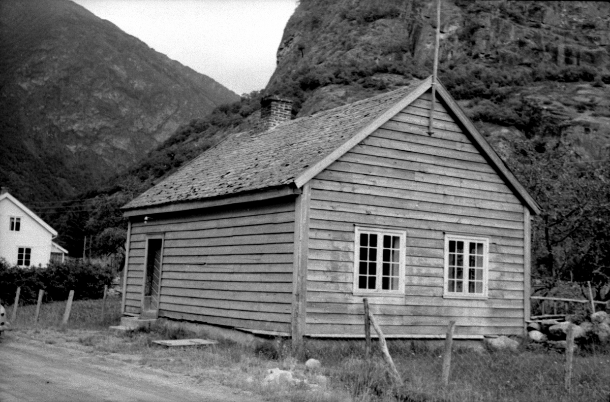 Ljøsne, Lærdal, Sogn og Fjordane, bygget 1866. Lite grått skolehus ved vei og mot fjell.. Registrering utført 1958-59 av Johan Schiong for Noregs Lærarlag. 