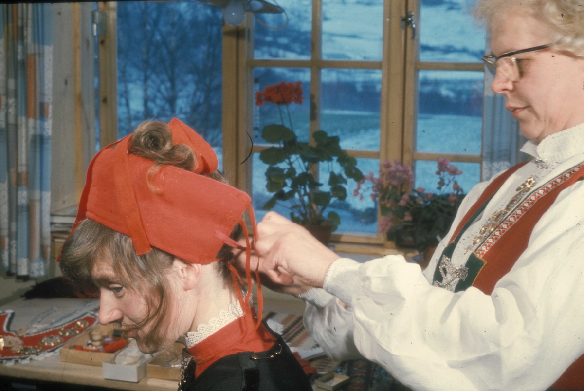 Brudepynting, Jølster 1967.Bruden, Eva Eide, får hjelp av Maria Gjesdal  med påkledningen. Valken settes på.
