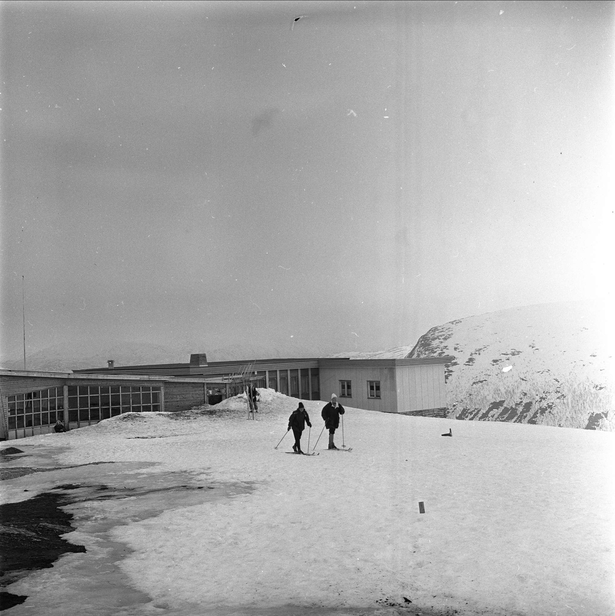 Tromsø, Troms, april 1963. Skiløpere foran bygning.