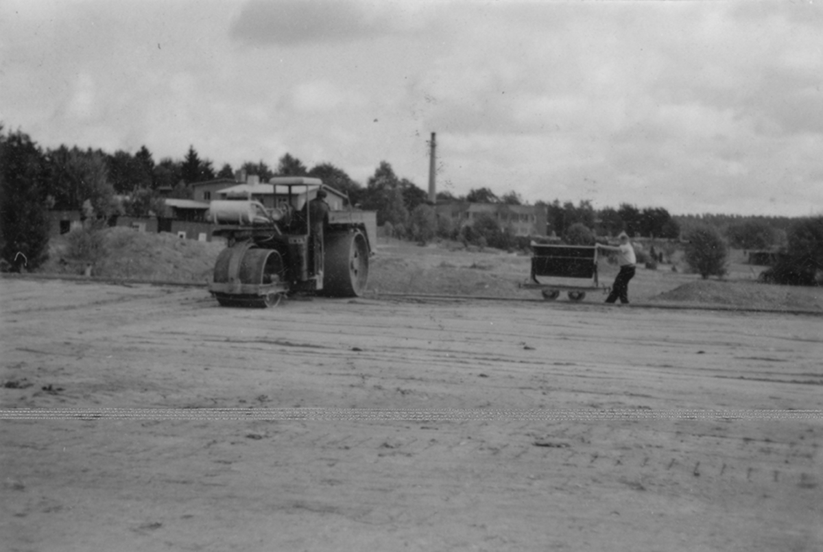 Idrottsplatsen på F 2 Roslagens flygflottilj byggs, 1943. Civilanställda tjänstemän i arbete med grävning. Människor och maskiner i arbete med grävning.